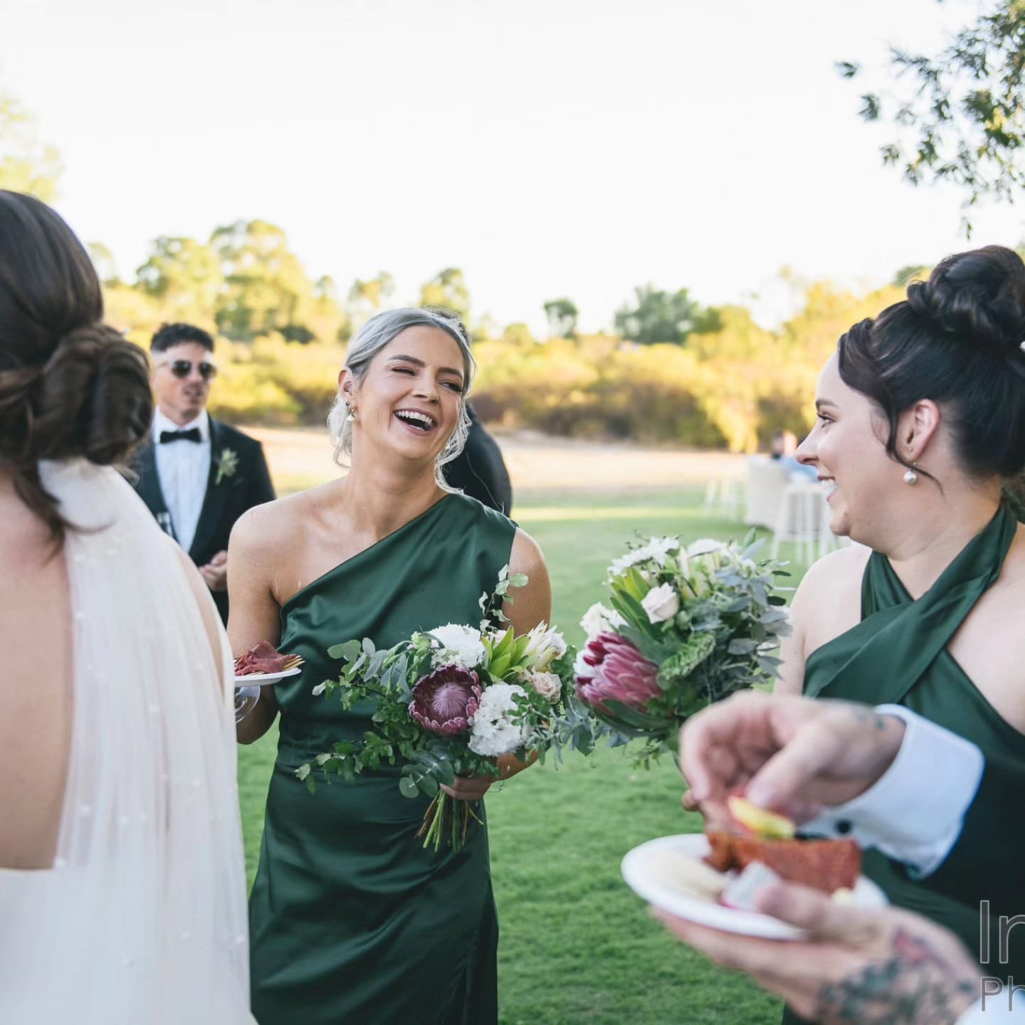 Bridesmaids laughing together at a Perth wedding in forest green custom dresses