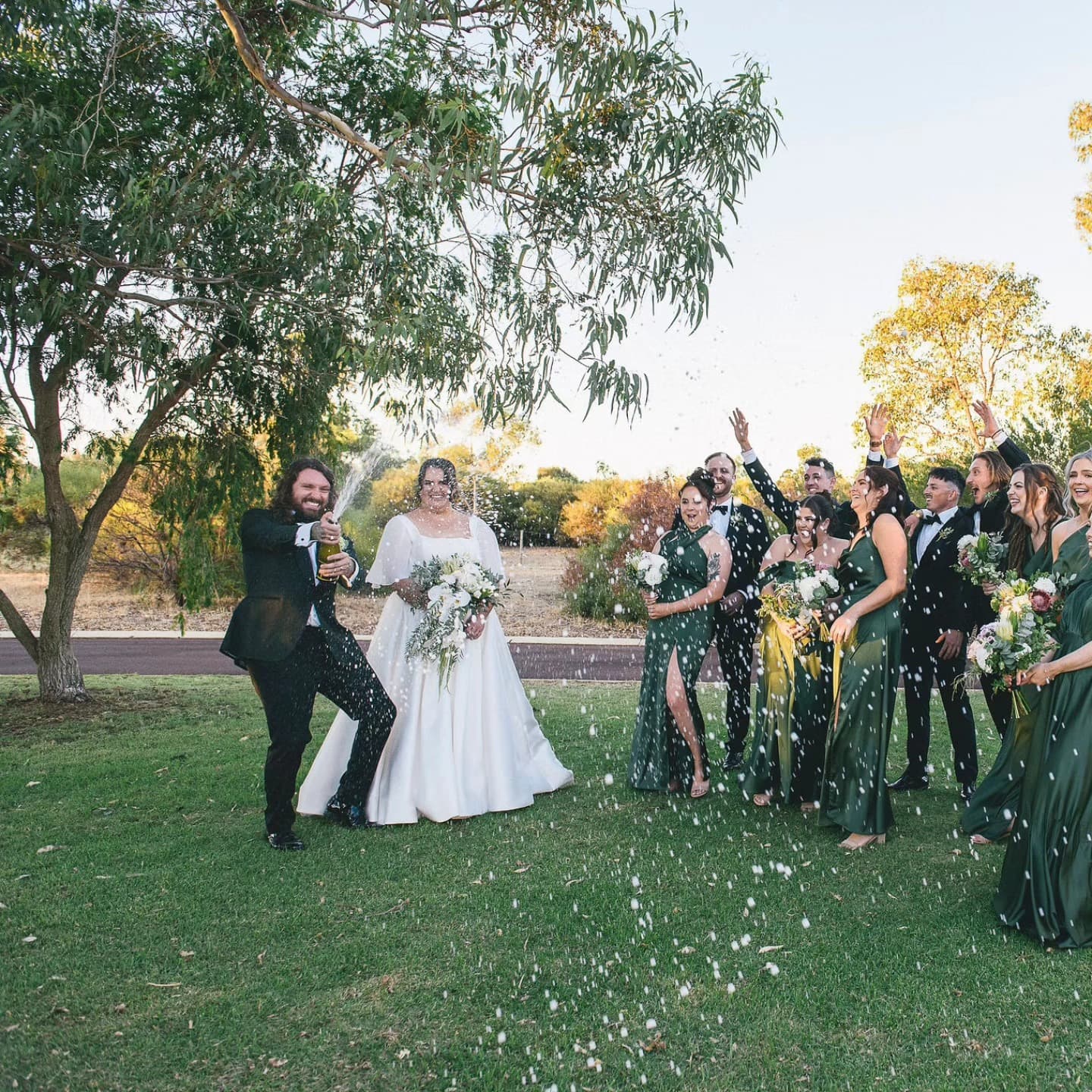 A bride and her party in custom dresses showered in confetti