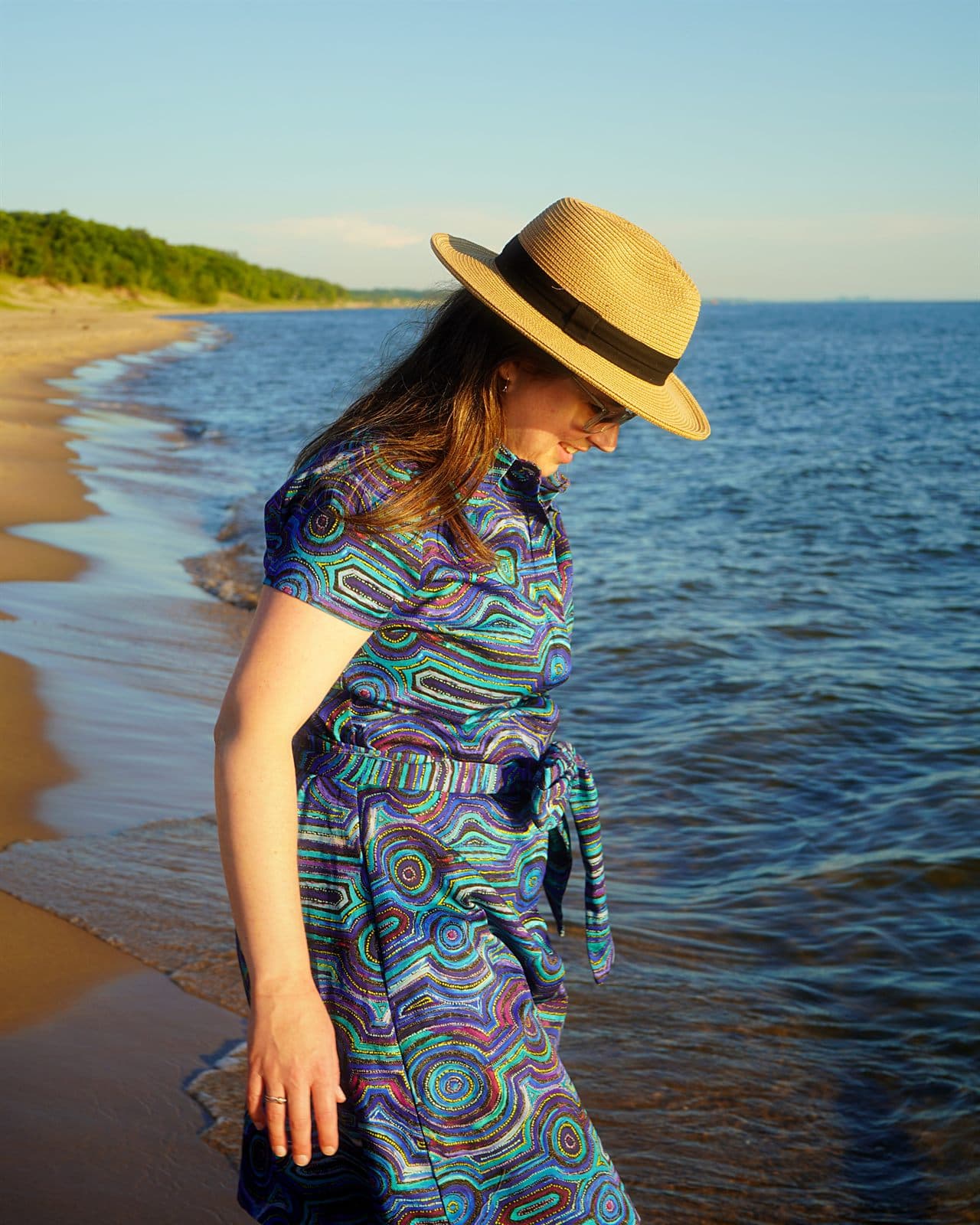 Mary wearing a blue Emu Dreaming cotton shirt dress with a waist tie by the lake.