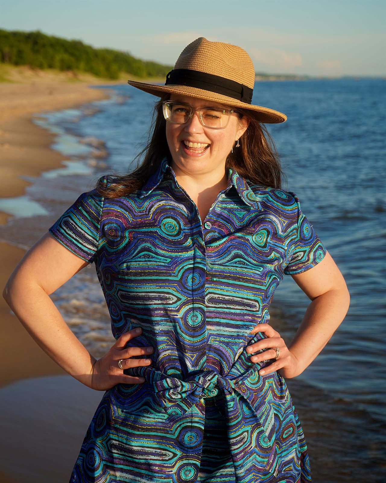 Mary wearing a blue Emu Dreaming cotton shirt dress with a waist tie by the lake.