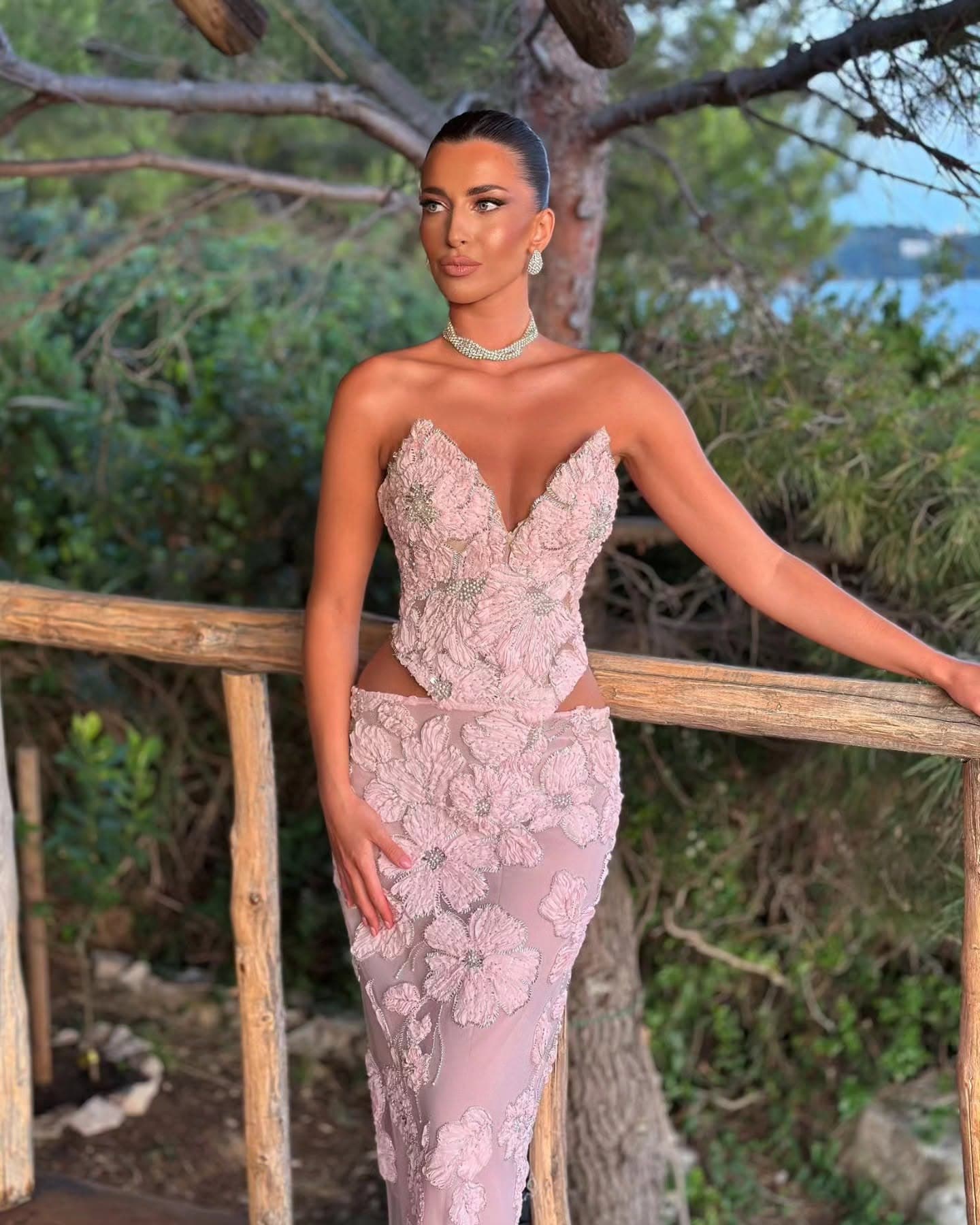 A custom blush gown with dimensional floral embroidery and beaded petal detail, worn at an evening event