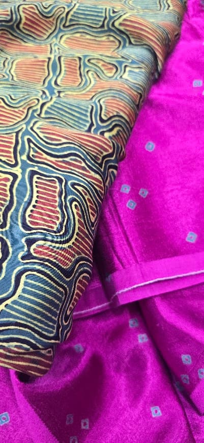 A First Nations printed fabric draped over magenta silk in the studio