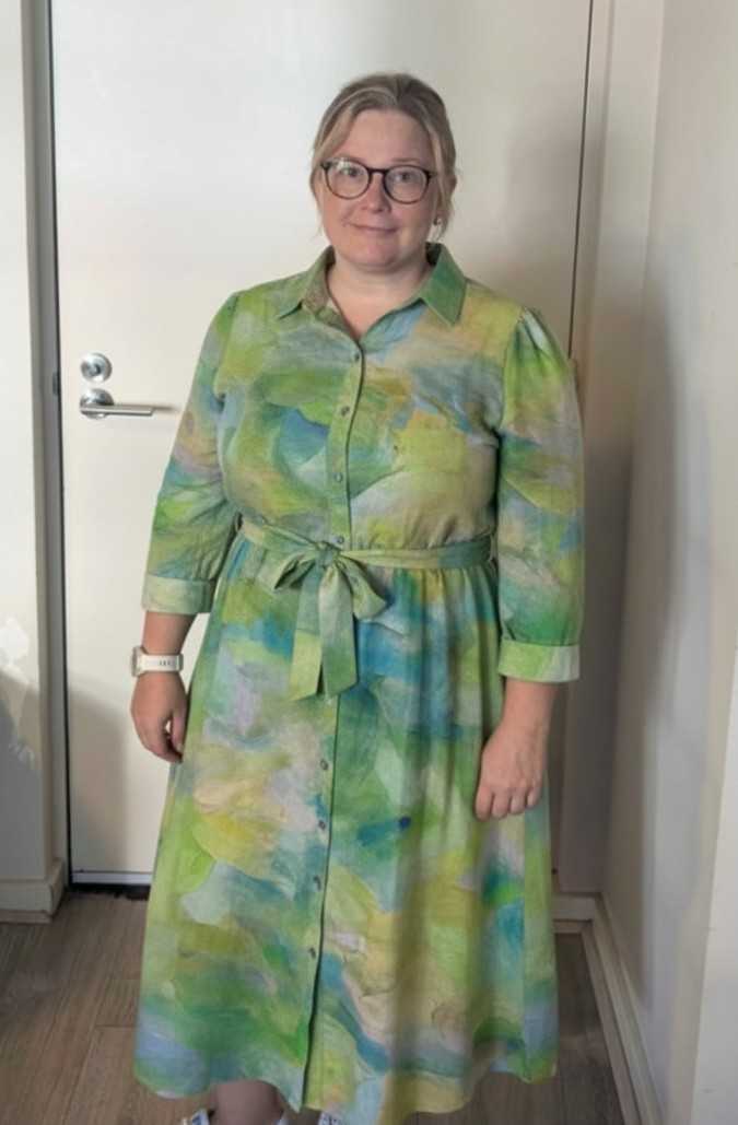 Erin trying on the finished green silk shirt dress at home
